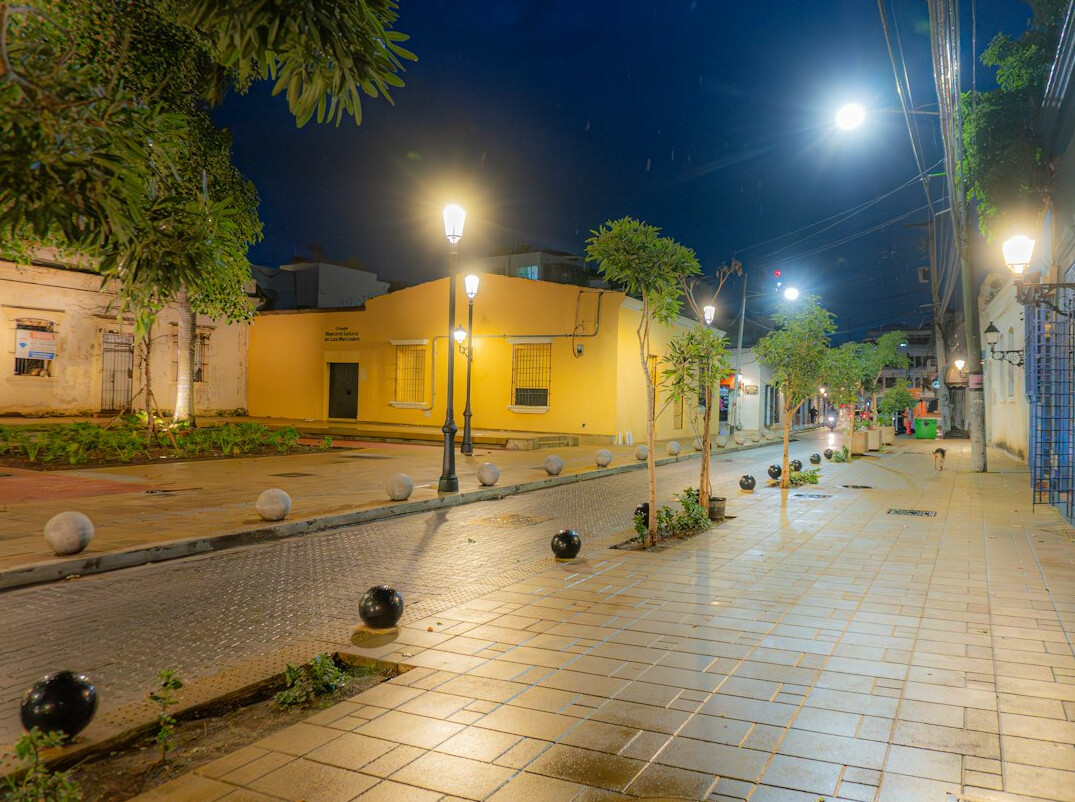 Rainy cobblestone street at night with streetlights