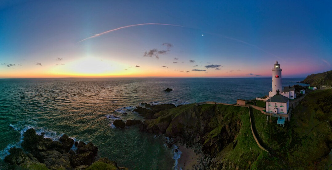 Lighthouse on a coastal point at dusk
