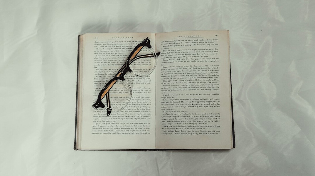 Open book with reading glasses resting on the pages